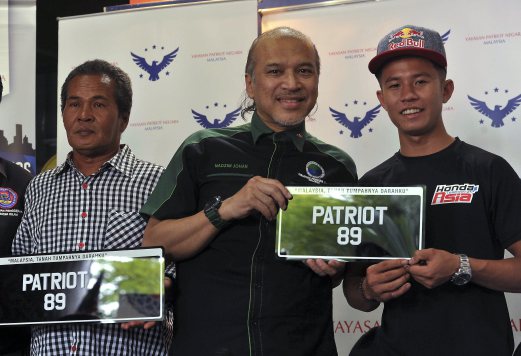 KUALA LUMPUR, 2 Ogos -- Ketua Aktivis Persatuan Pengguna Islam Malaysia (PPIM), Datuk Nadzim Johan (tengah) menyerahkan plat kenderaan PATRIOT 89 keoada pelumba Moto3 negara, Khairul Idham Pawi (kanan) semasa menyampaikan tajaaan melalui Yayasan Patriot Negara Malaysia (YPNM) hari ini.    Turut hadir bapa Khairul, Pawi Omar (kiri). --fotoBERNAMA (2016) HAK CIPTA TERPELIHARA?